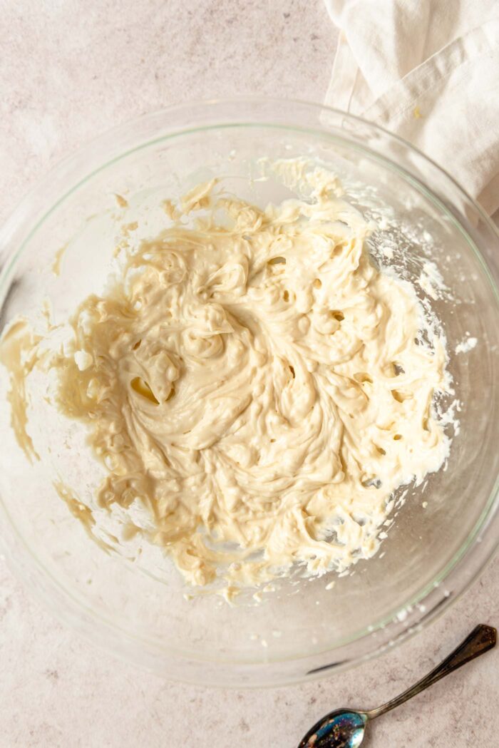 Butter and sugar whipped into a light and fluffy mixture in a glass mixing bowl.