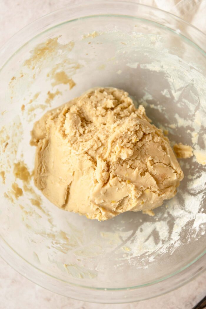 A ball of shortbread cookie dough in a glass mixing bowl.