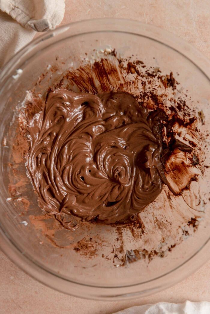 A smooth and creamy melted chocolate mixture in a glass mixing bowl.