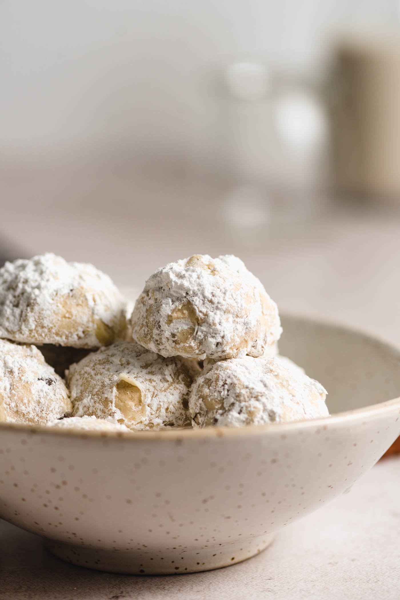 Powdered sugar-coated snowballs cookies in a small bowl.
