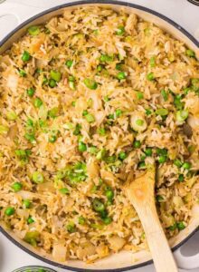 A large skillet of cabbage fried rice with green peas and onion.