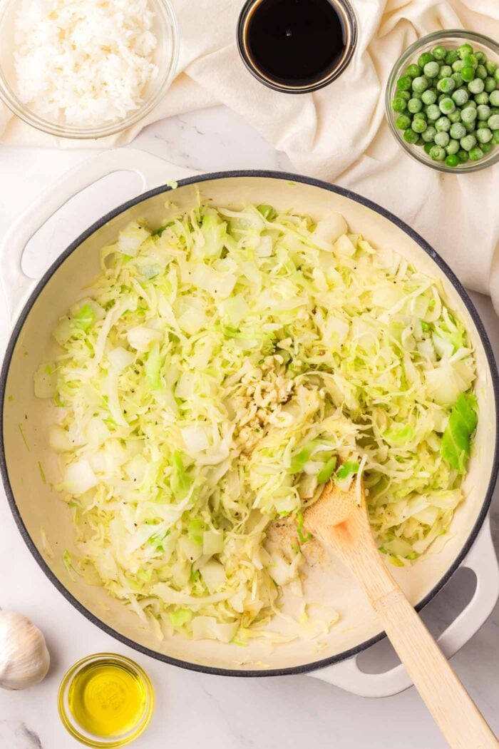 Cabbage, onion and garlic cooking in a large skillet.