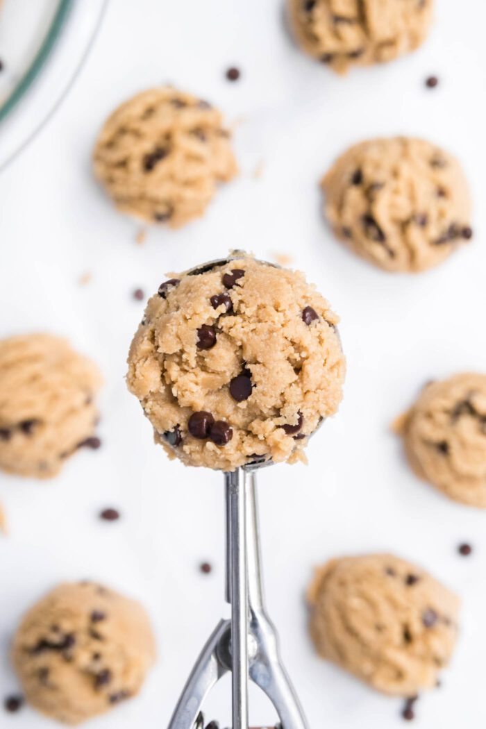 A cookie scoop filled with edible chocolate chip cookie dough.