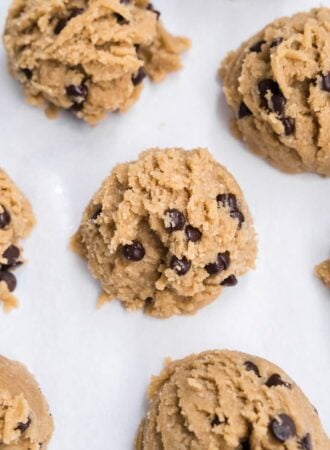 Overhead close up of scoops of chocolate chip cookie on a baking sheet.