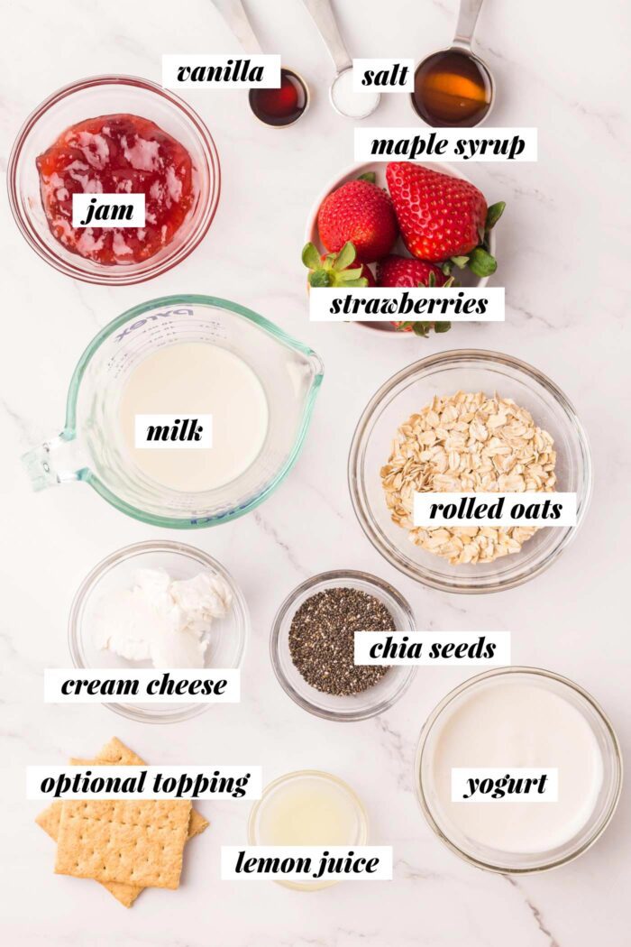 All of the ingredients needed for making a vegan overnight oats recipe with strawberries, chia seeds and yogurt.