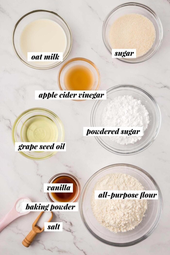 All the ingredients needed for making vegan baked glazed donuts. Each ingredient is labelled with text overlay.