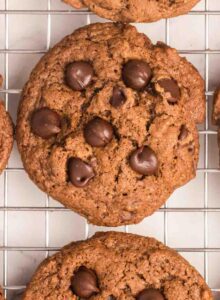 Overhead view of a double chocolate chip cookie on a metal cooling rack.