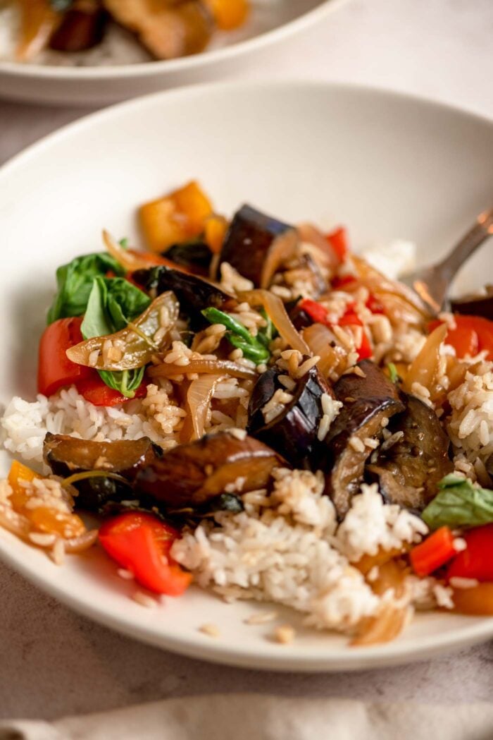 Stir fried Thai basil eggplant mixed with rice in a bowl.