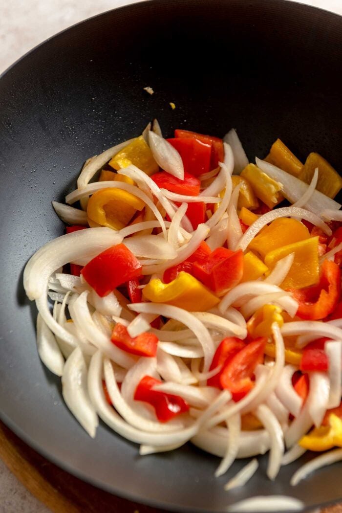 Stir fried peppers and onions in a large wok.