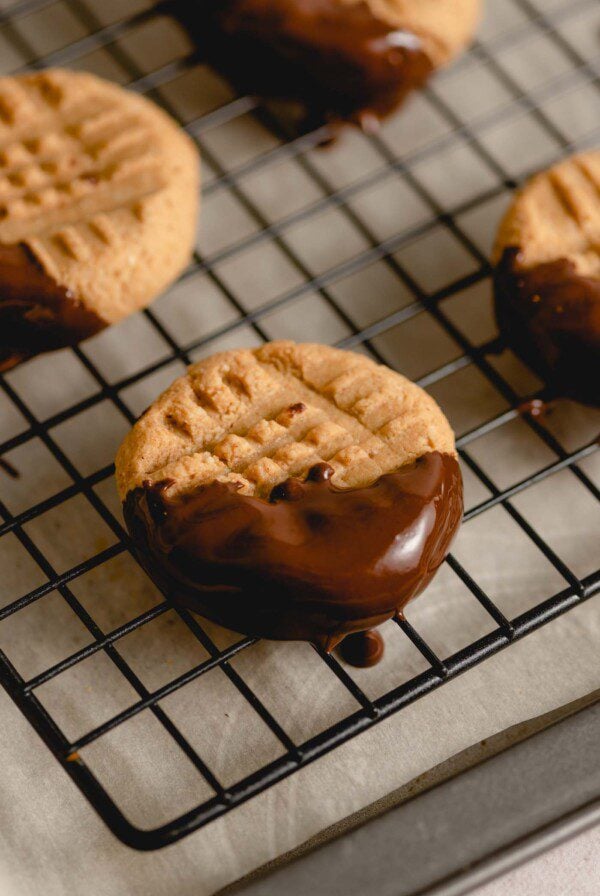 A peanut butter cookie that's dipped in chocolate covering half of the cookie.