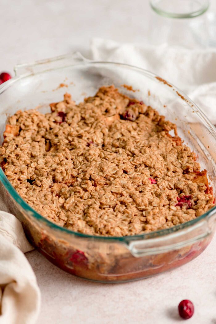 A baked cranberry apple crisp in an oval glass baking dish.