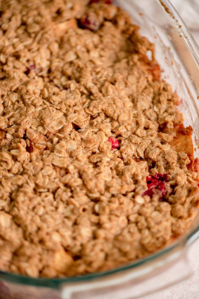 Close up of an apple cranberry crumble in a glass baking dish.