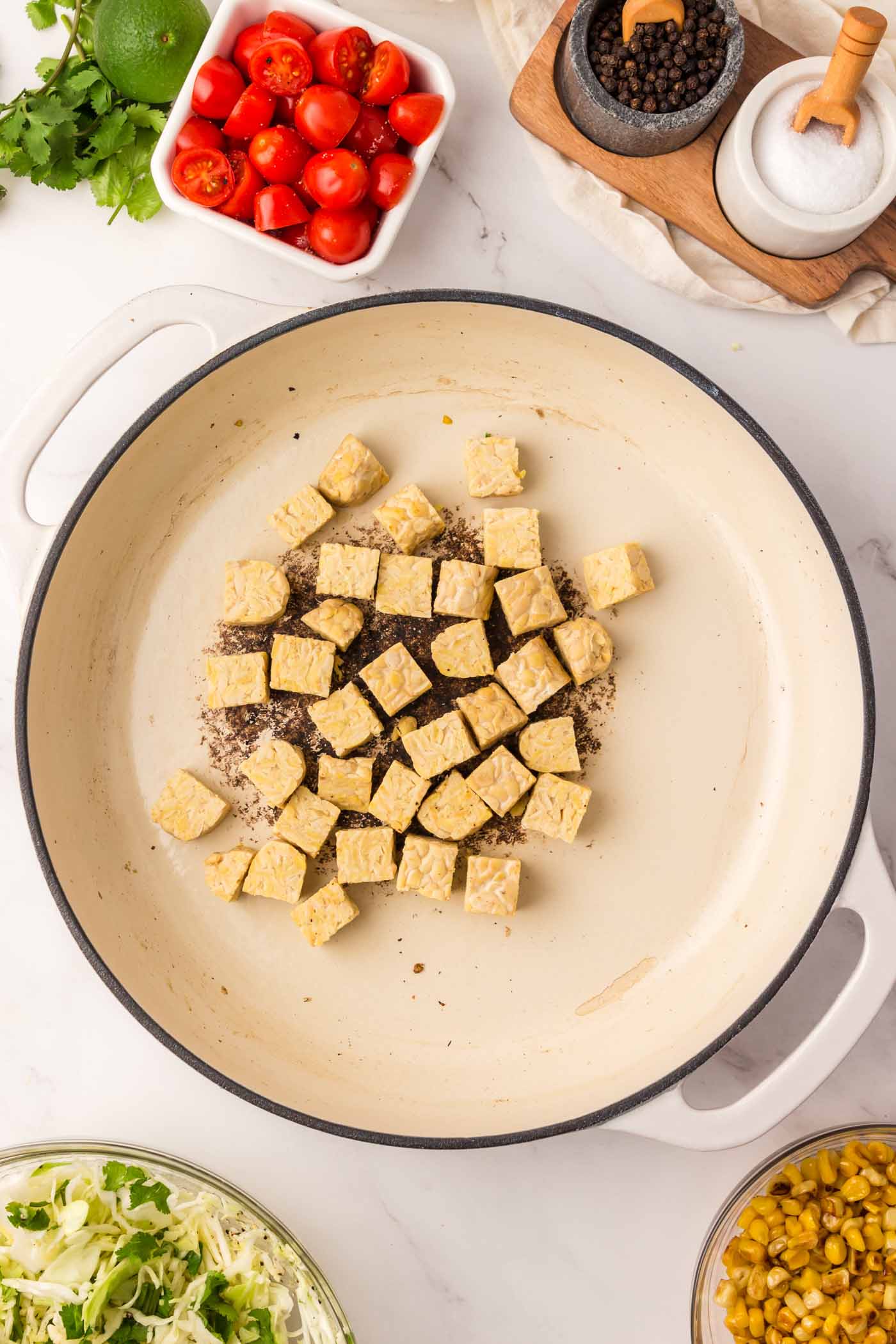 Cubes of tempeh cooking in a pan.