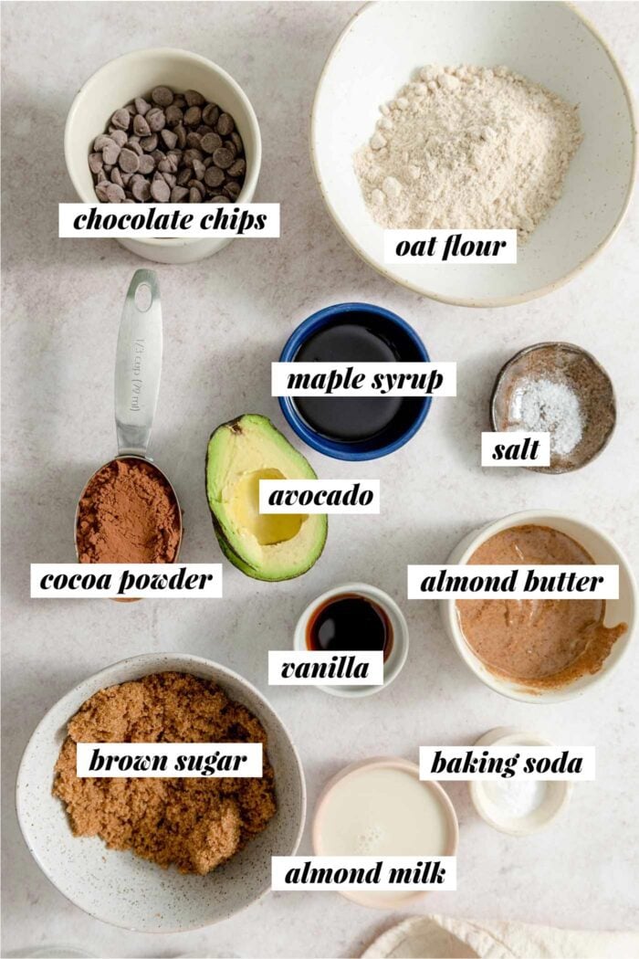 All the ingredients needed for making a vegan avocado brownie recipe with oat flour, brown sugar, maple syrup and chocolate chips.