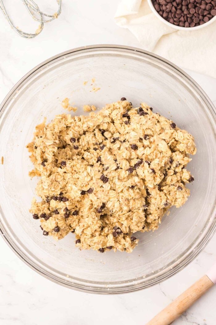 Almond flour chocolate chip oatmeal cookie dough in a large glass mixing bowl.
