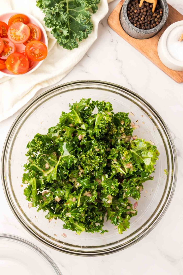 Kale mixed with dressing in a large mixing bowl.