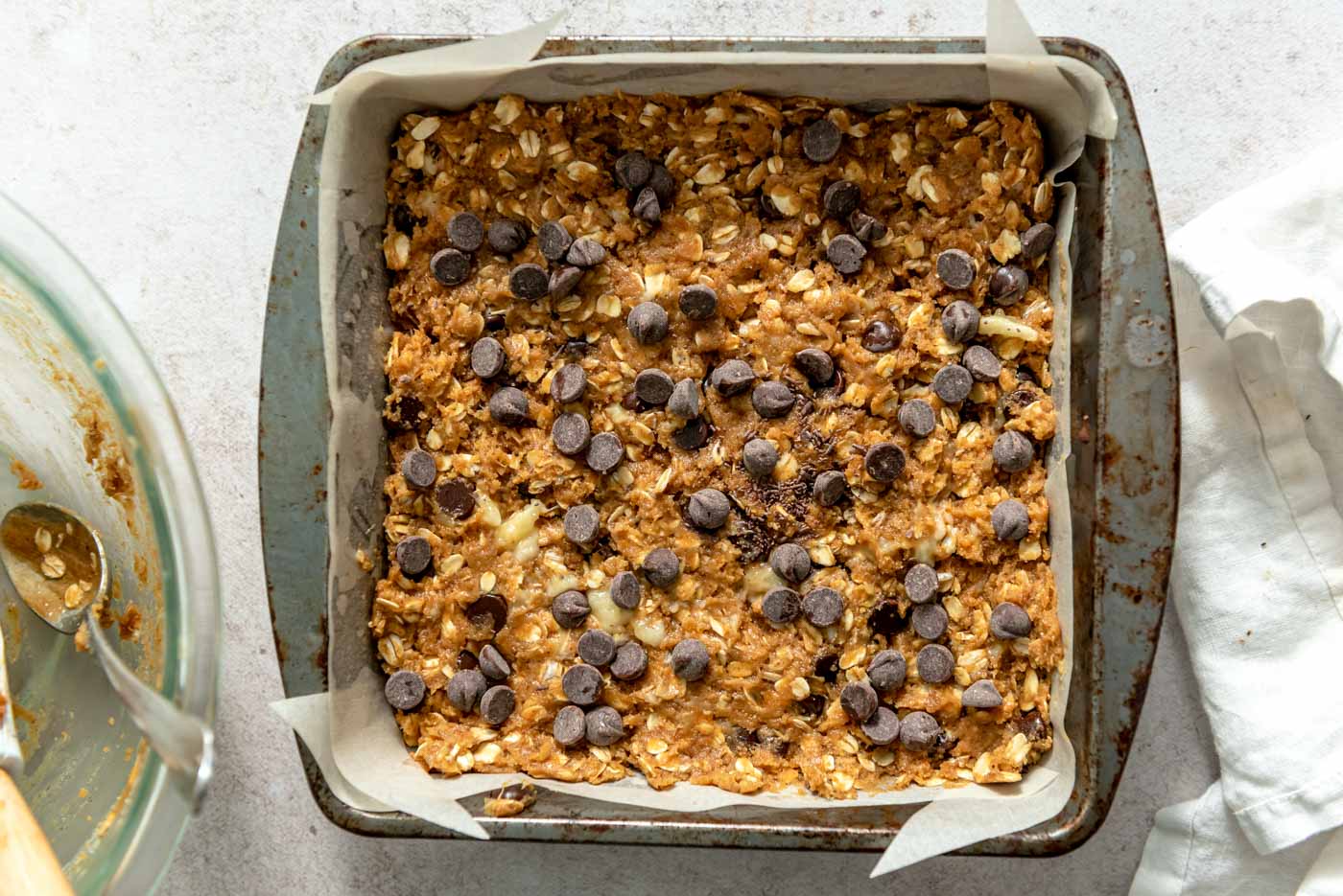 Overhead view into a pan of oatmeal chocolate chip cookie bars.