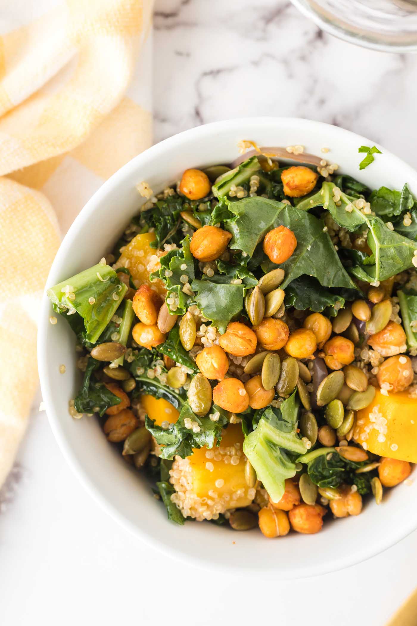 A small bowl of roasted butternut squash quinoa salad with roasted chickpeas and pumpkin seeds.