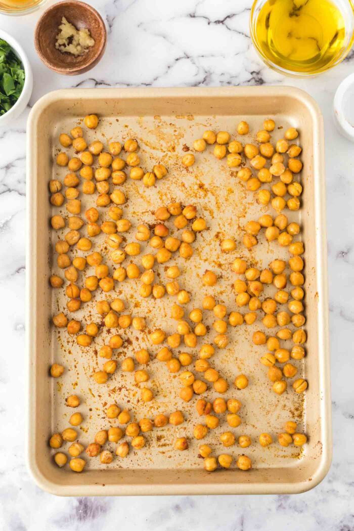 Roasted chickpeas on a baking pan.