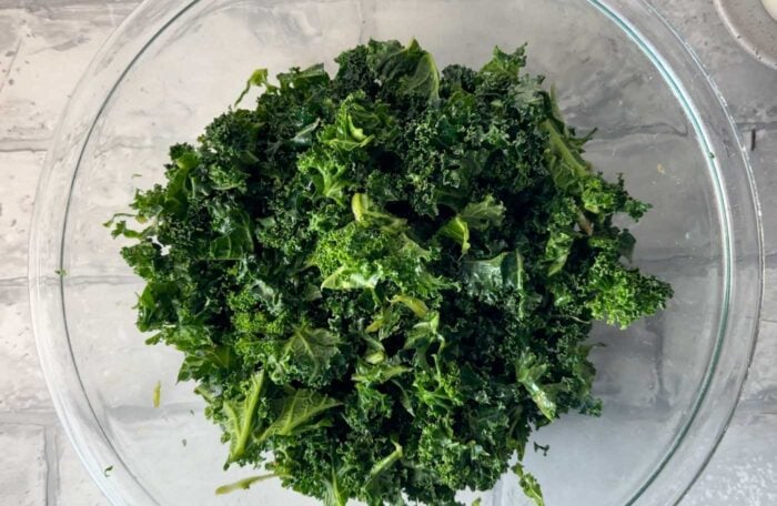 Chopped kale in a glass mixing bowl.