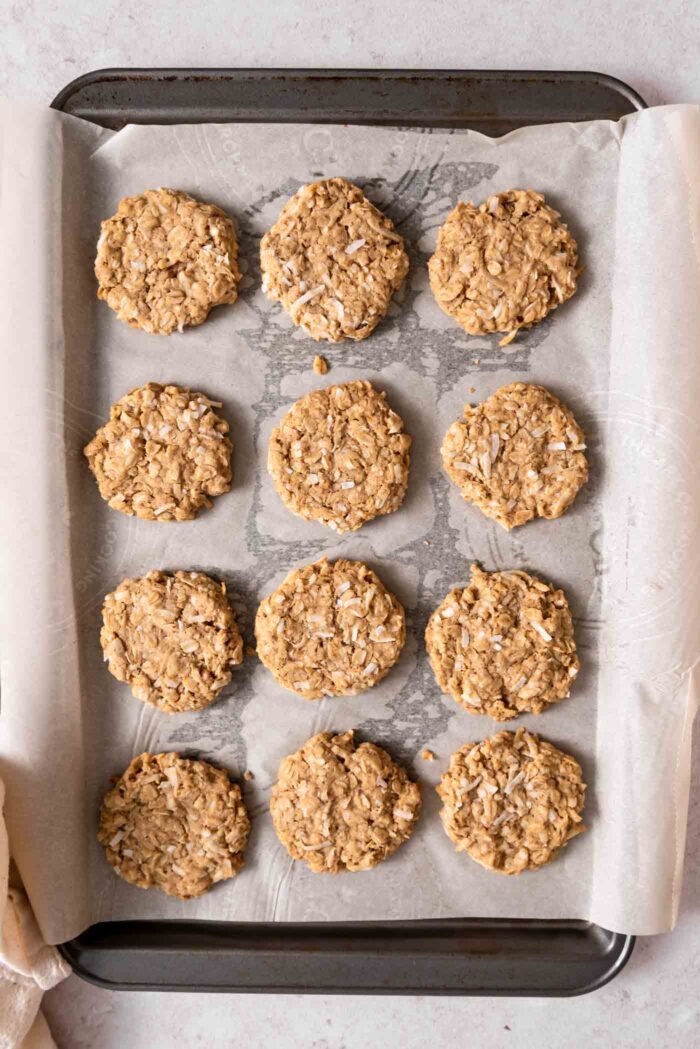 12 coconut oatmeal cookies on a baking sheet.