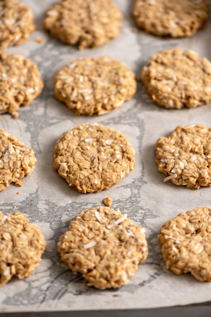 Coconut oatmeal cookies on a baking sheet lined with parchment paper.