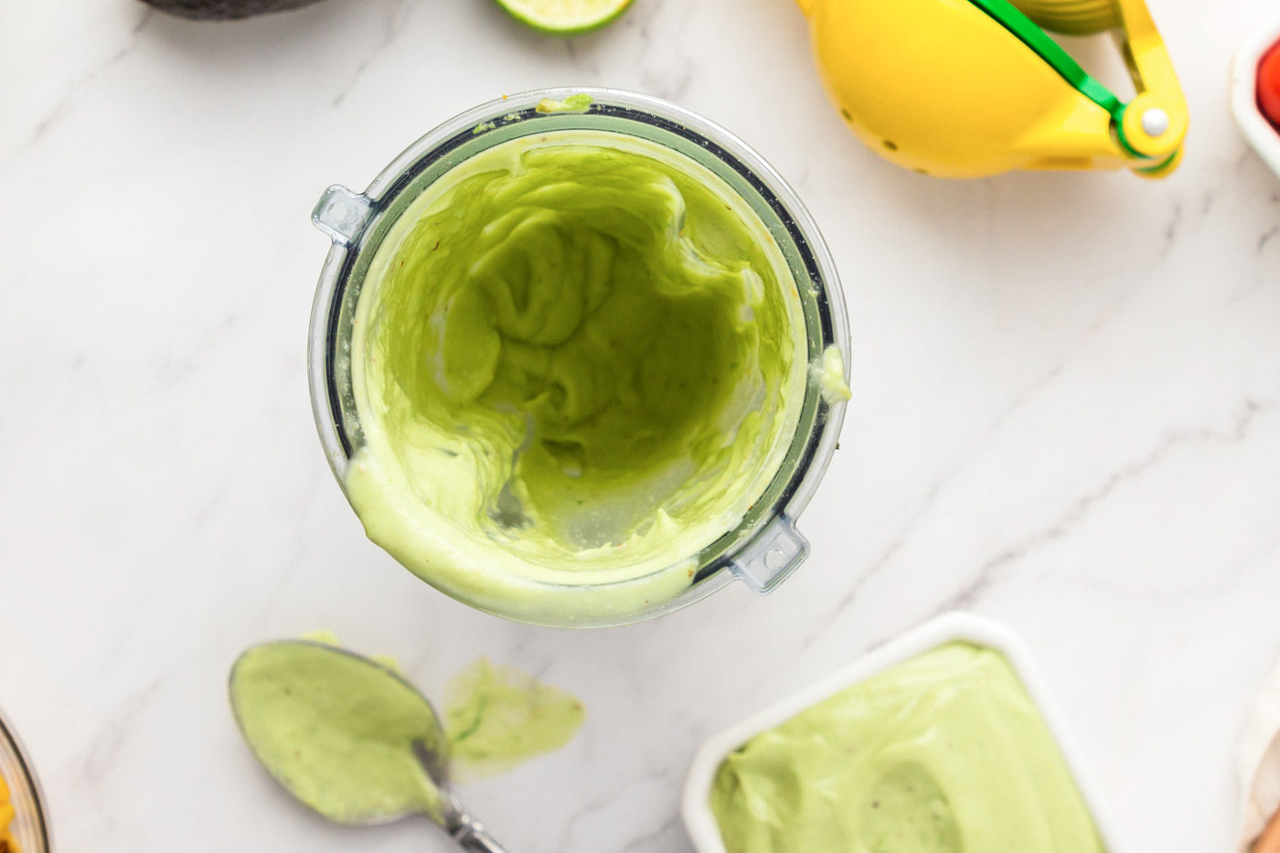 A creamy avocado sauce in a small blender container.