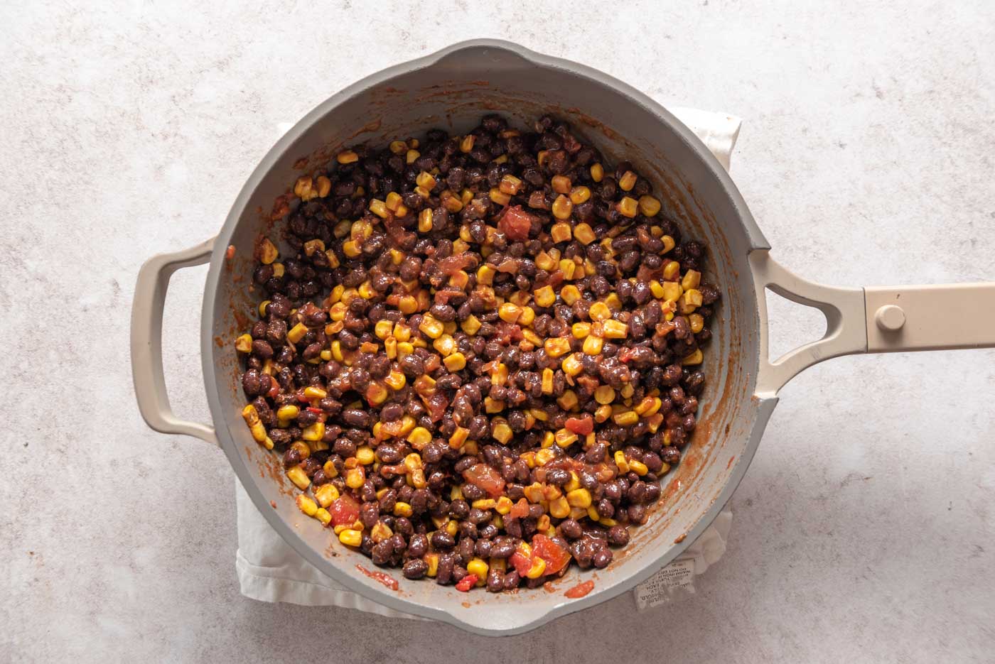 Beans, corn and salsa cooking in a skillet.