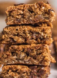 A stack of 4 gluten-free oatmeal cookie bars with chocolate chips in them.