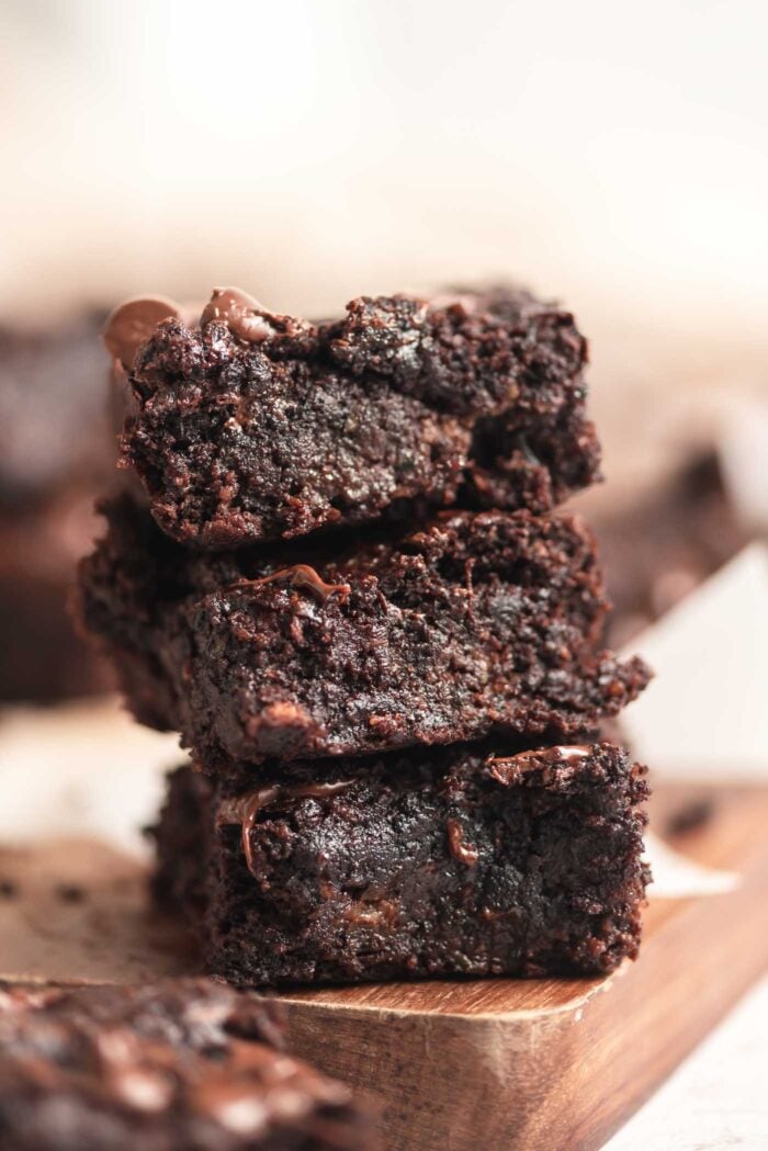 A stack of 3 zucchini brownies with chocolate chips in them.