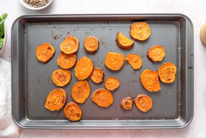 Roast sweet potato wedges on a baking sheet.