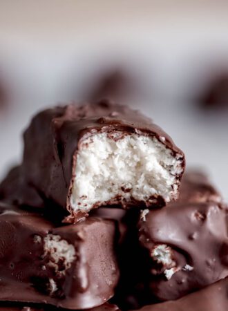 A homemade Mounds candy bar with a bite taken from it so you can see the texture of the creamy coconut filling.