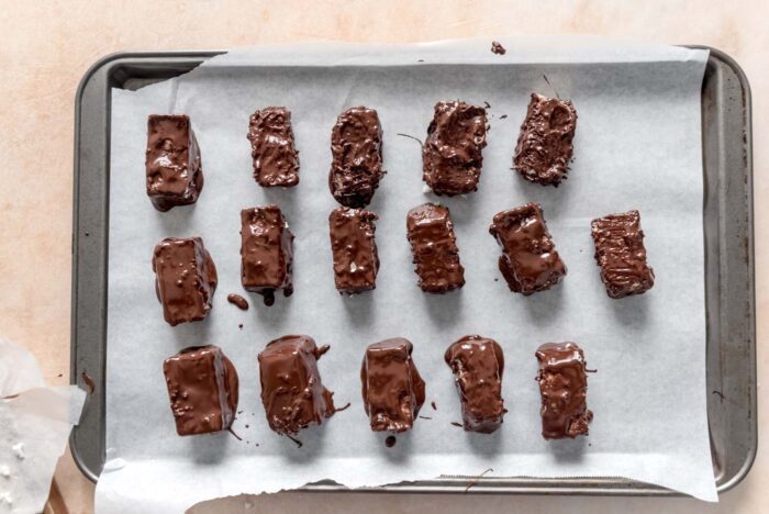 16 homemade Mounds candy bars on a baking sheet lined with parchment paper.