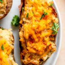 Twice baked potatoes topped with cheese, parlsey and paprika.