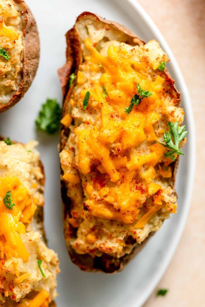 Twice baked potatoes topped with cheese, parlsey and paprika.