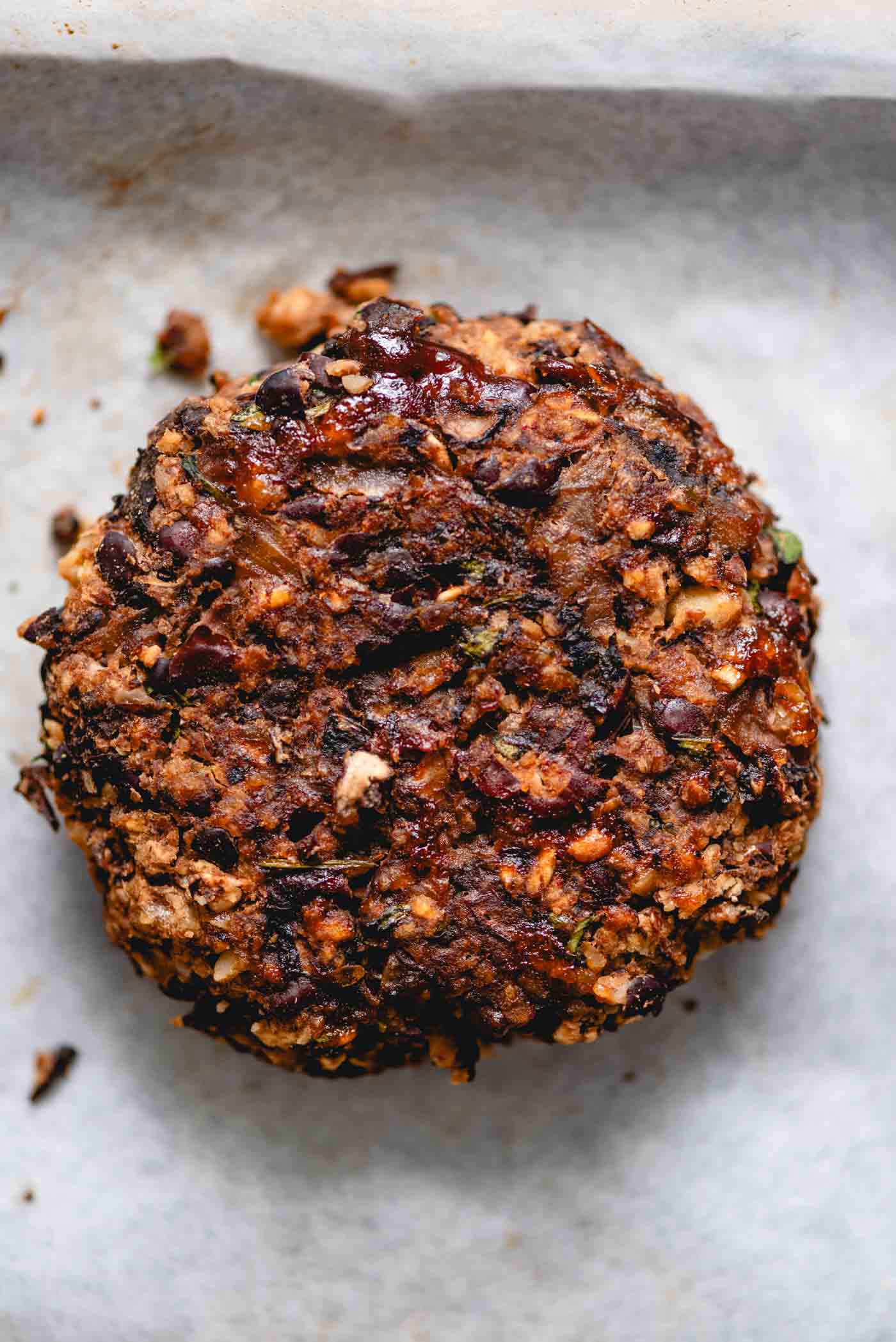 Baked black bean veggie burger on a parchment paper lined baking sheet.