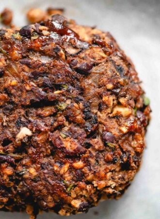 Veggie mushroom burger with black beans, onions and walnuts on a baking sheet lined with parchment paper.