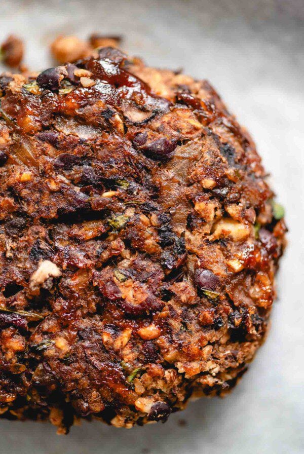 Veggie mushroom burger with black beans, onions and walnuts on a baking sheet lined with parchment paper.