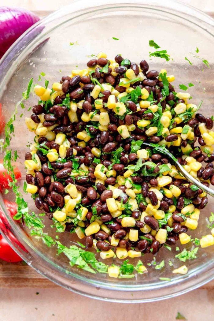 Black beans, corn and cilantro in a glass bowl.