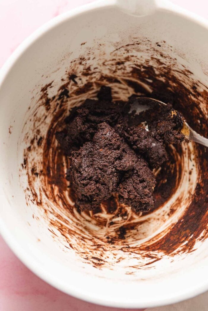 Chocolate fudge dough mixed together in a large glass mixing bowl.