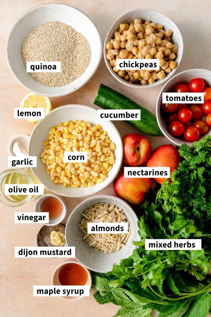 All the ingredients for a summer quinoa salad recipe gathered in bowls and each labelled with text overlay.