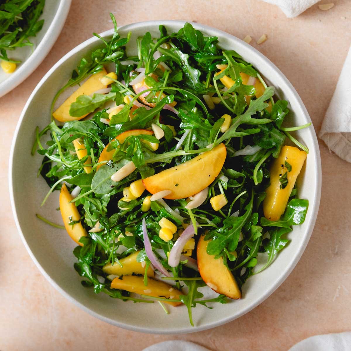 https://runningonrealfood.com/wp-content/uploads/2023/06/vegan-corn-almond-peach-arugula-salad-recipe-1-4.jpg