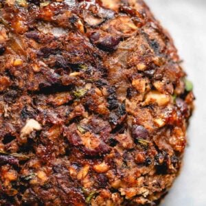 Veggie mushroom burger with black beans, onions and walnuts on a baking sheet lined with parchment paper.