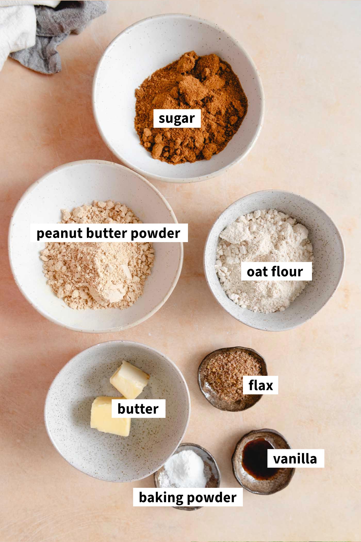 Ingredients for making peanut butter powder cookies. Each ingredient is labelled.