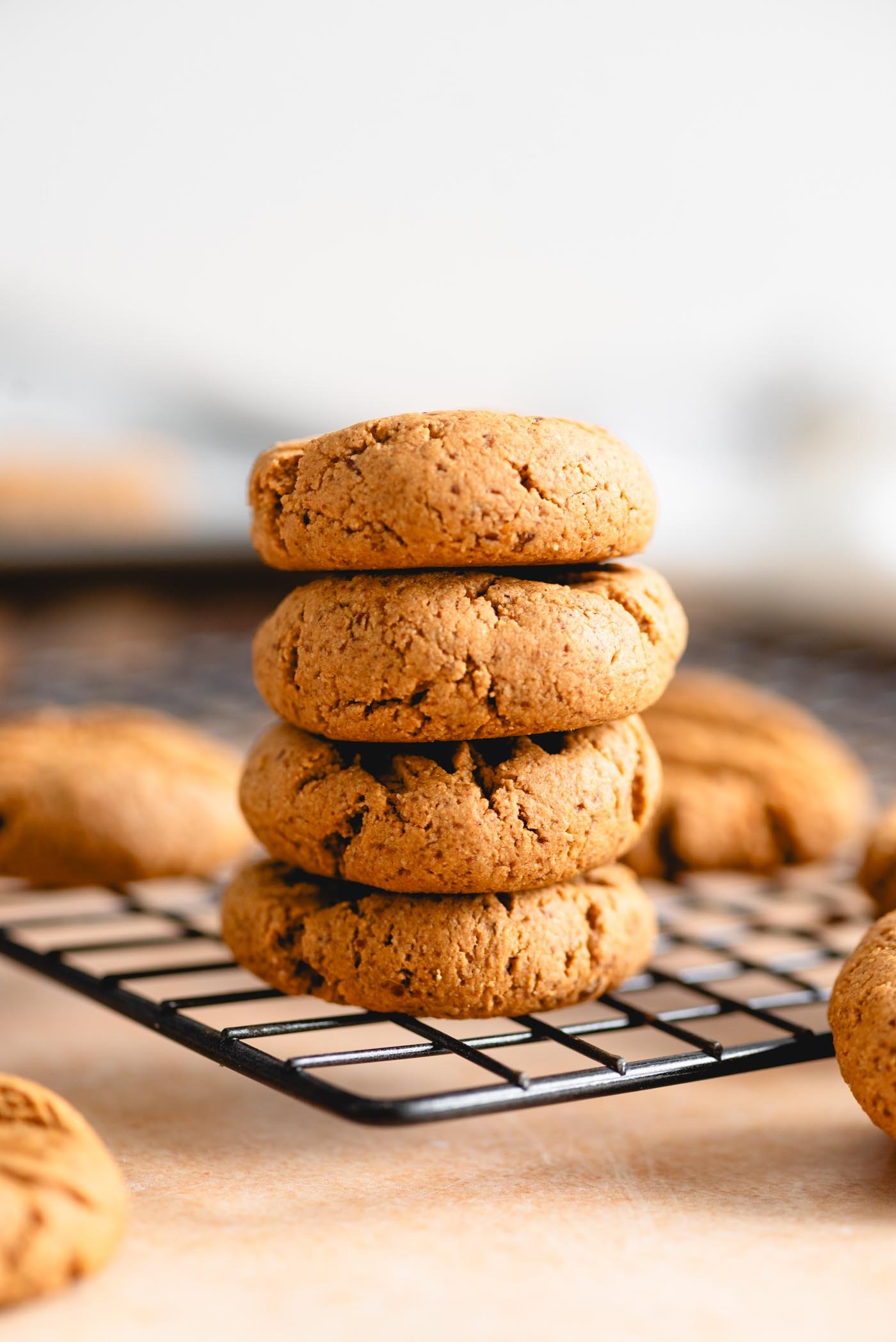 Stack of 4 peanut butter cookies on a wire baking rack.