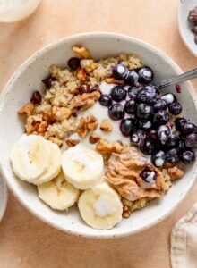 Quinoa breakfast bowl with banana, blueberries, walnuts, chocolate chips and yogurt.