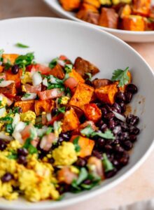 Breakfast burrito bowl with tofu scramble, black beans, roasted sweet potato and salsa all mixed together.