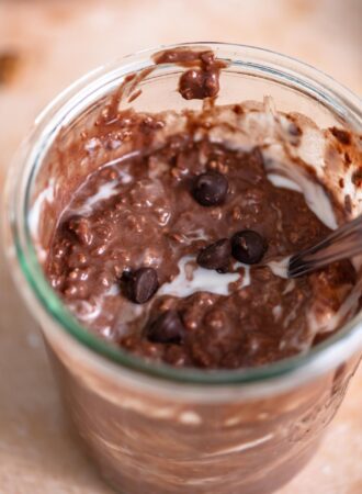 Jar of overnight chocolate protein oats with a few chocolate chips sprinkled over top.