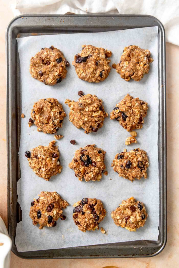 12 cranberry orange oatmeal cookies on a baking sheet lined with parchment paper.