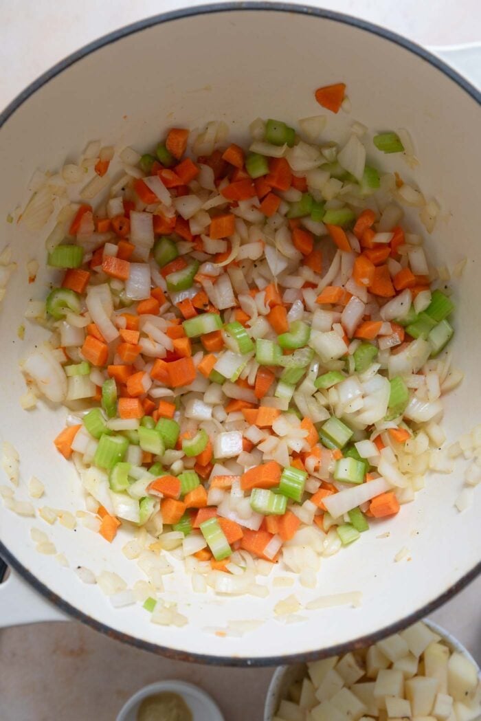 Diced onion, carrot and celery cooking in a large pot.